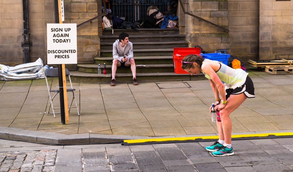 Woman with hands on knees, tired from a race