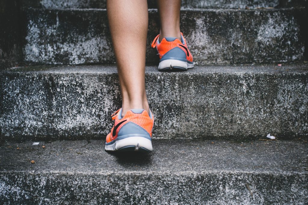 Half Marathon Workouts - Runner with shoes visible climbing stairs